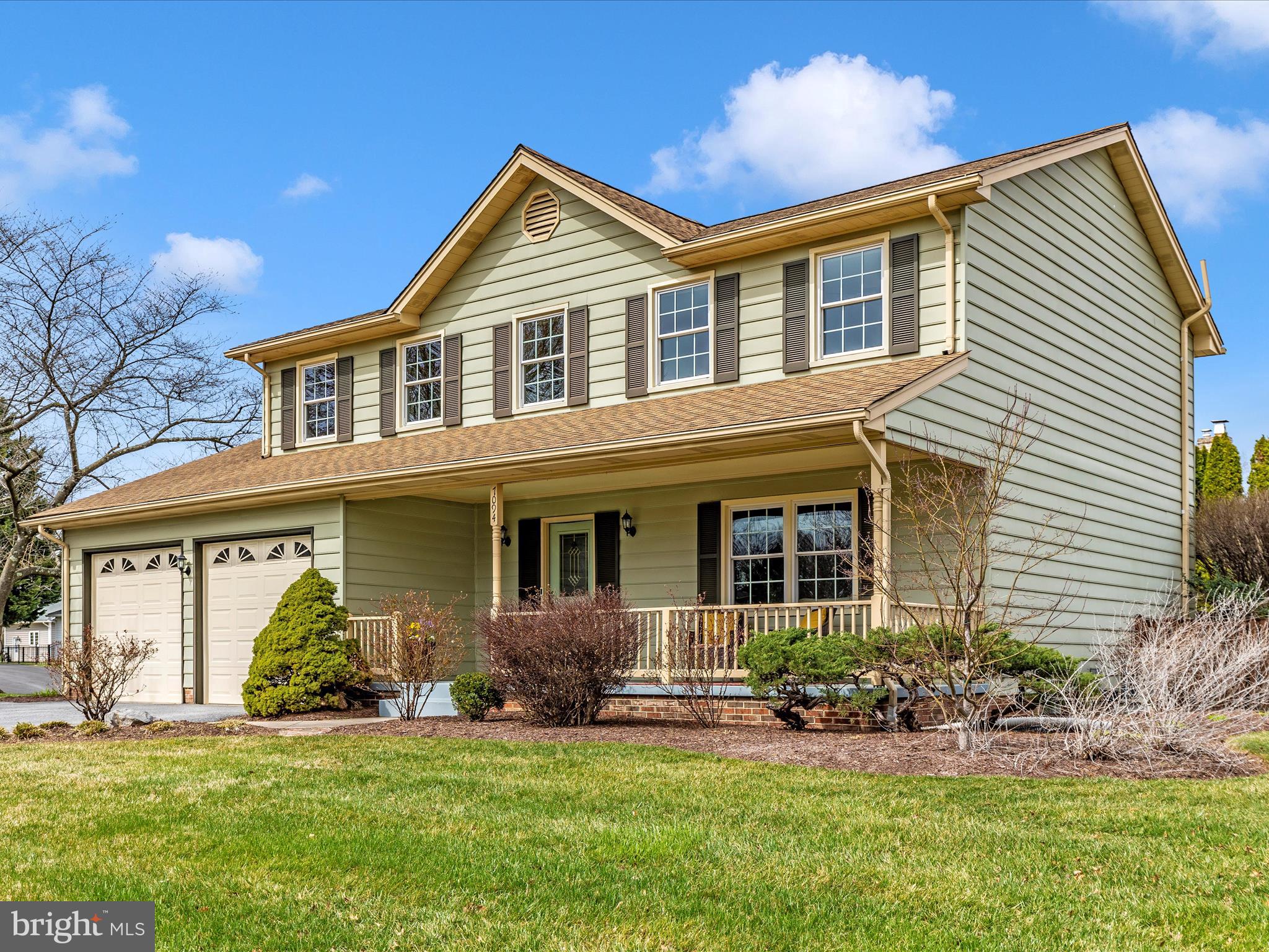 a front view of a house with a yard and potted plants