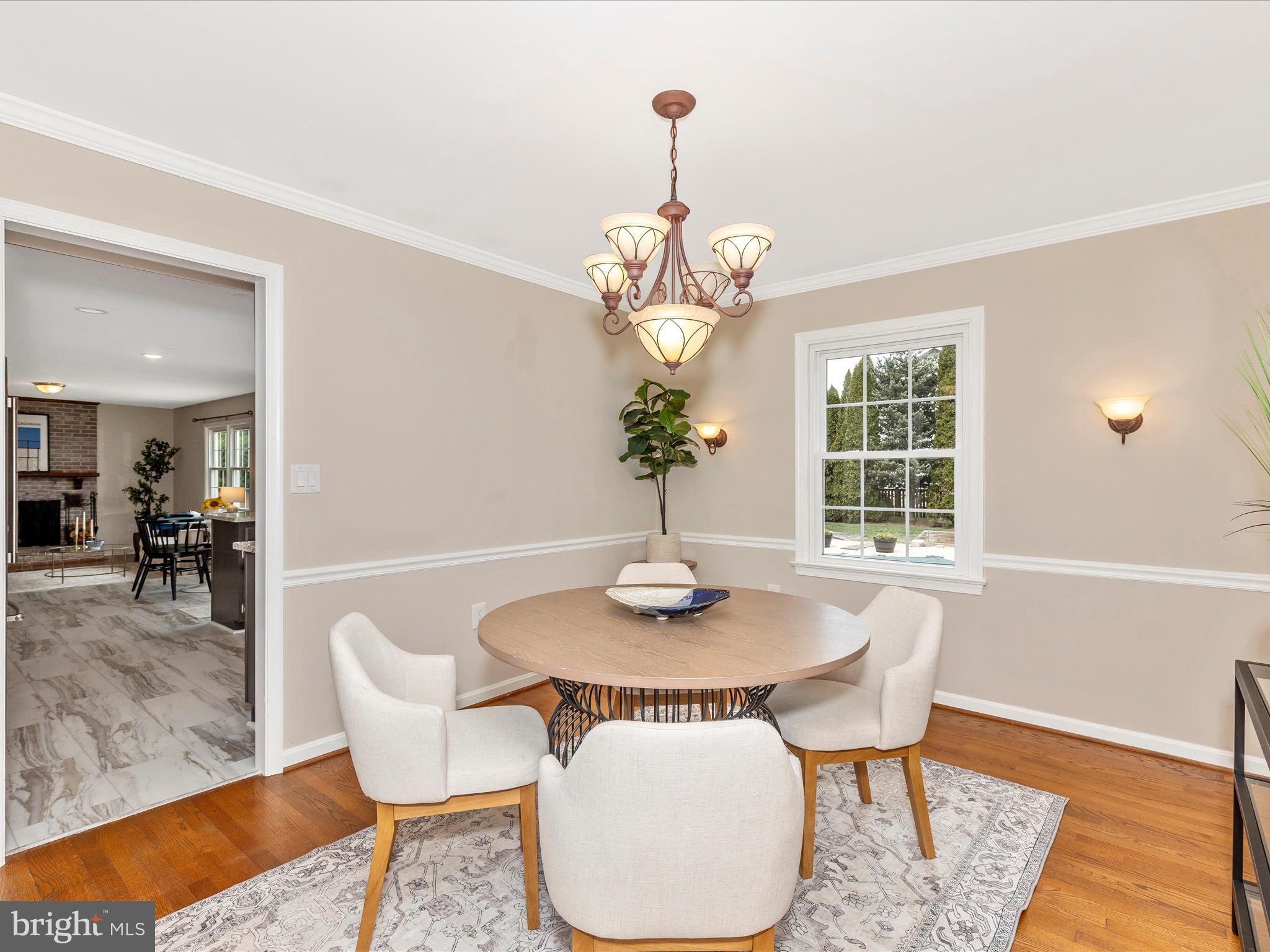 7094 Autumn Leaf Lane Frederick, MD 21702 - Photo 7 of 43 a dining room with wooden floor a chandelier a wooden table and chairs