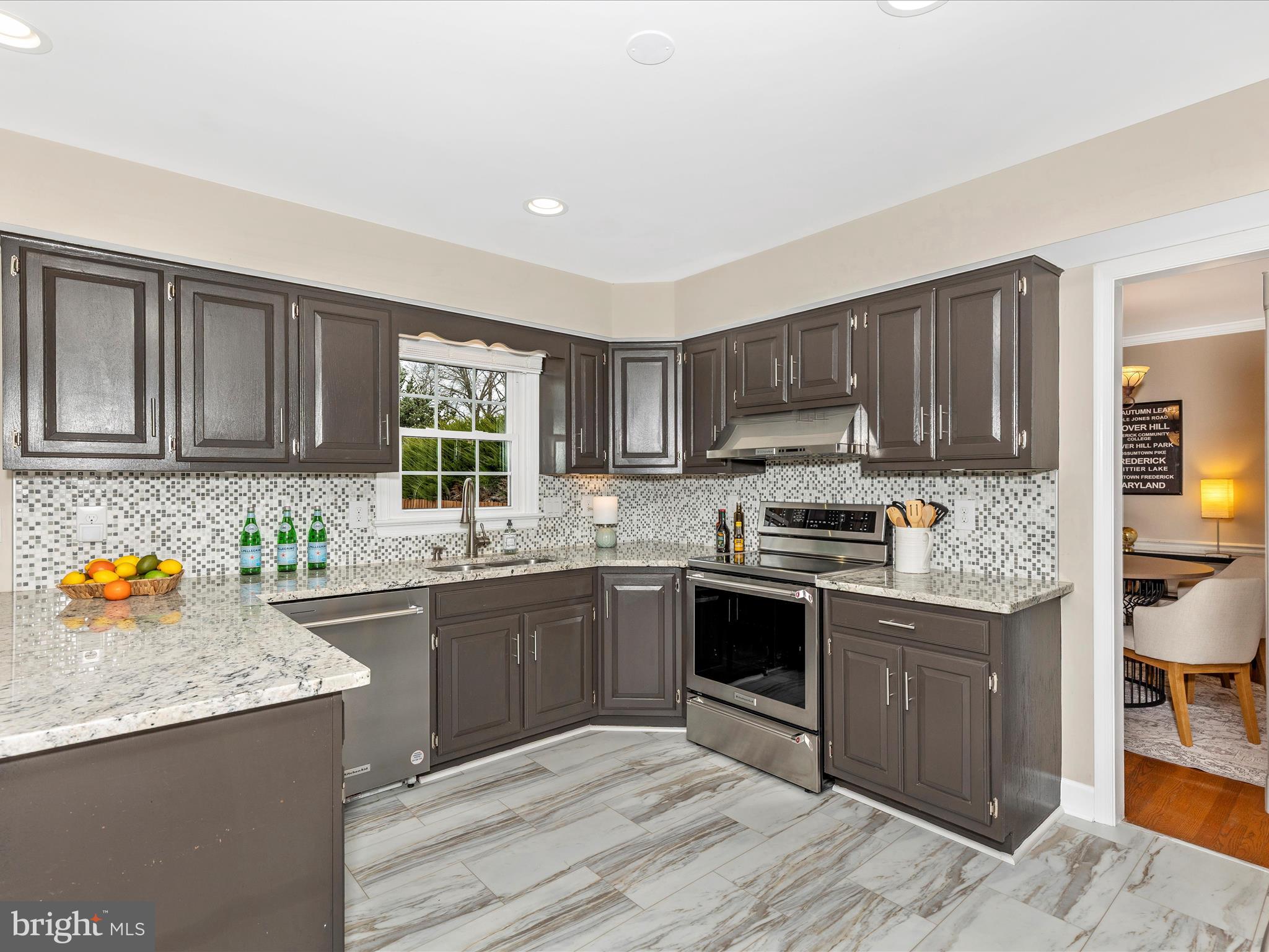 7094 Autumn Leaf Lane Frederick, MD 21702 - Photo 9 of 43 a kitchen with stainless steel appliances granite countertop wooden cabinets a stove top oven a sink and dishwasher with wooden floor