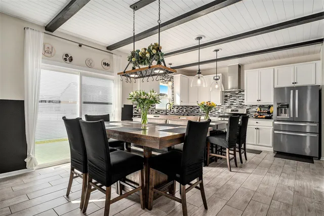 a dining room with stainless steel appliances kitchen island granite countertop furniture and a kitchen view