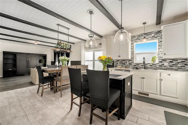 a dining hall with stainless steel appliances kitchen island granite countertop furniture and a kitchen view
