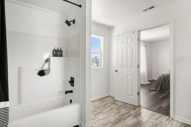 a bathroom with a tub shower vanity and a sink