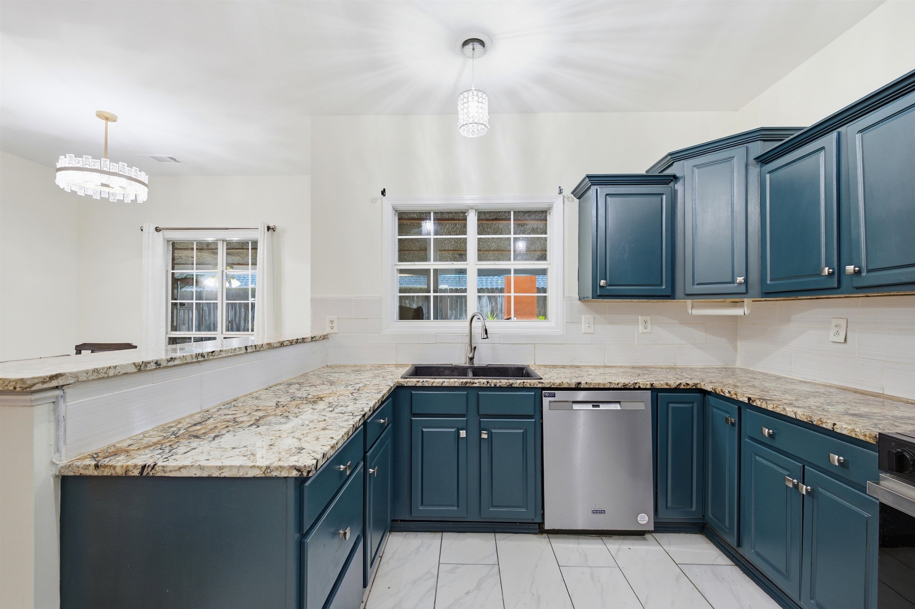 96 Berryfield Cove Collierville, TN 38017 - Photo 13 of 39 Kitchen featuring deep teal cabinetry, light granite countertops, stainless steel dishwasher, white subway tile backsplash, and white wood-finish flooring