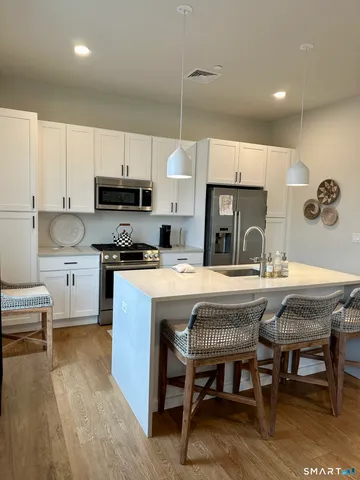 a kitchen with kitchen island granite countertop a table chairs sink microwave and cabinets
