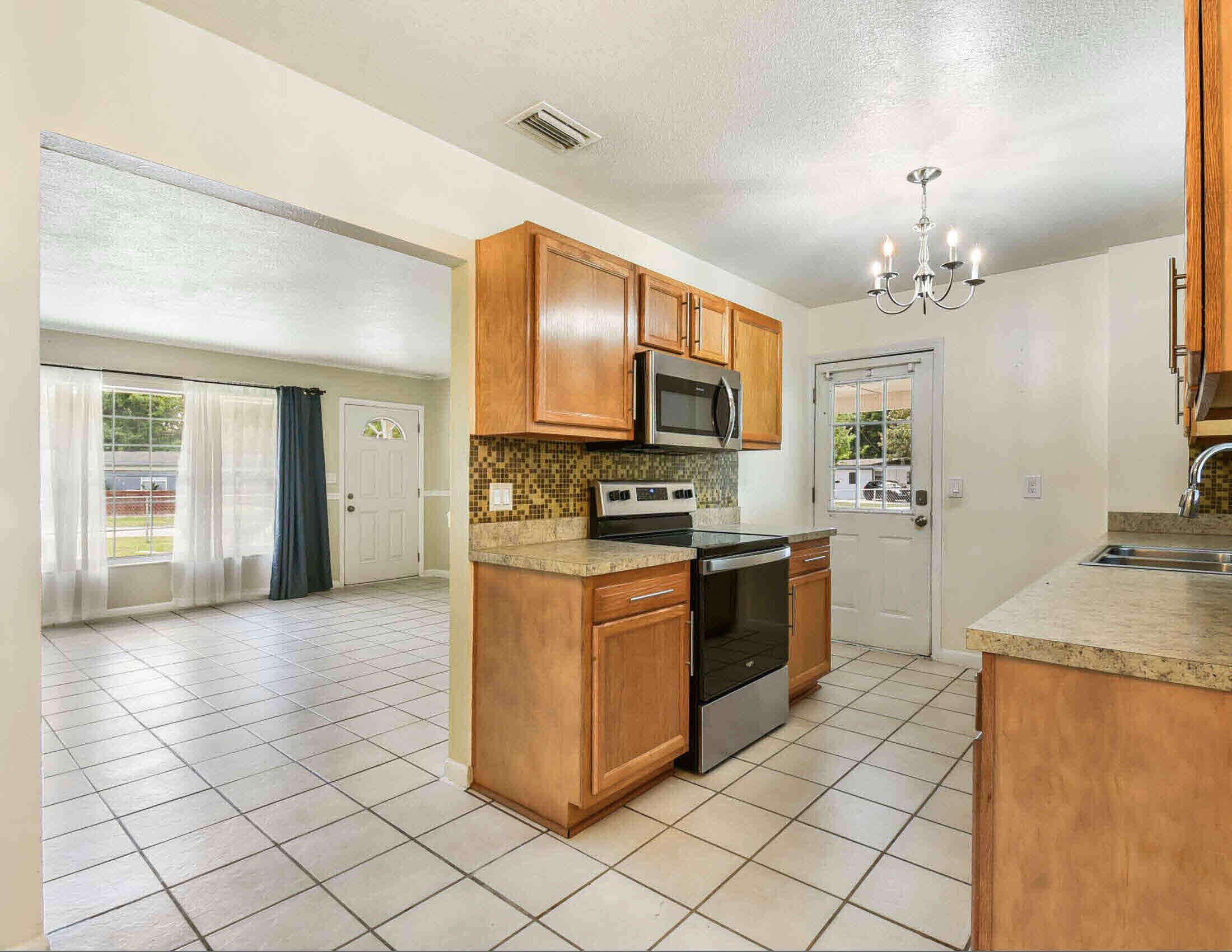10403 Ebbitt Road Jacksonville, FL 32246 - Photo 15 of 22 a kitchen with stainless steel appliances granite countertop a stove top oven a sink a counter top space and cabinets