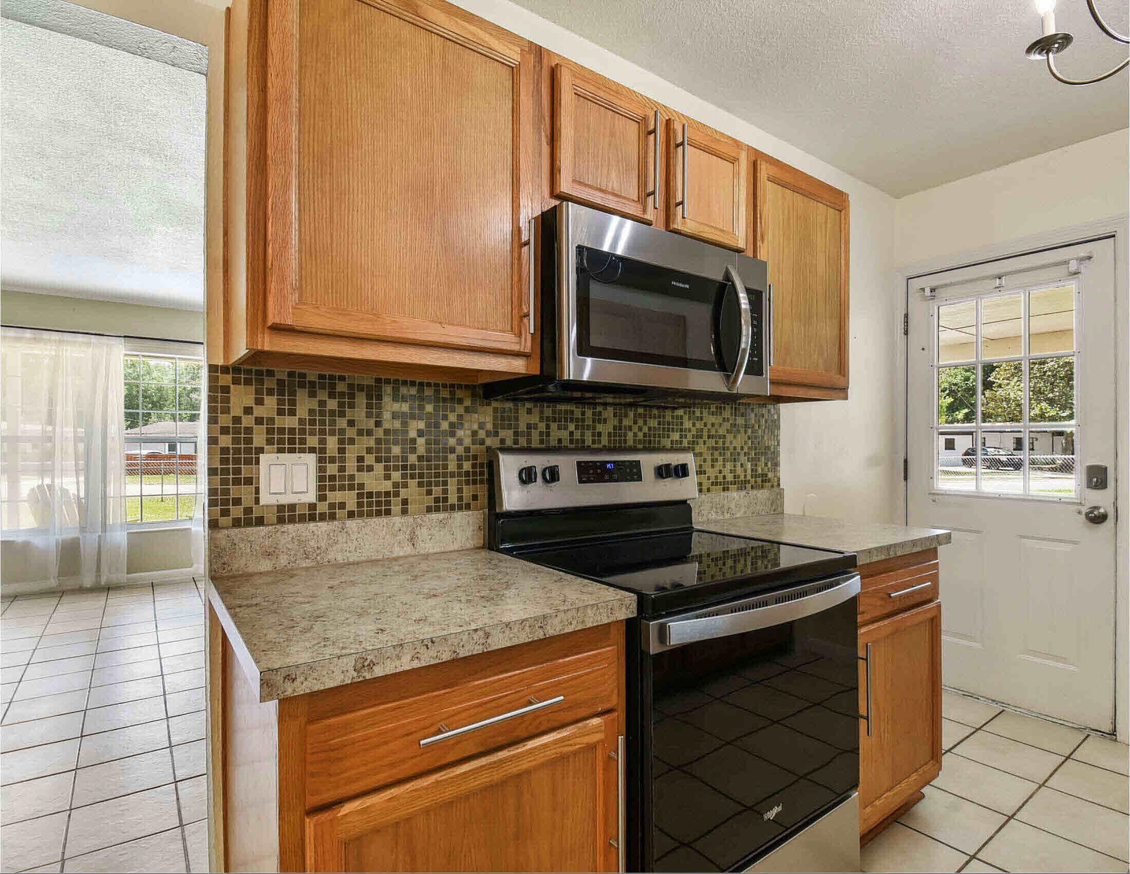 10403 Ebbitt Road Jacksonville, FL 32246 - Photo 17 of 22 a kitchen with granite countertop a stove sink and microwave