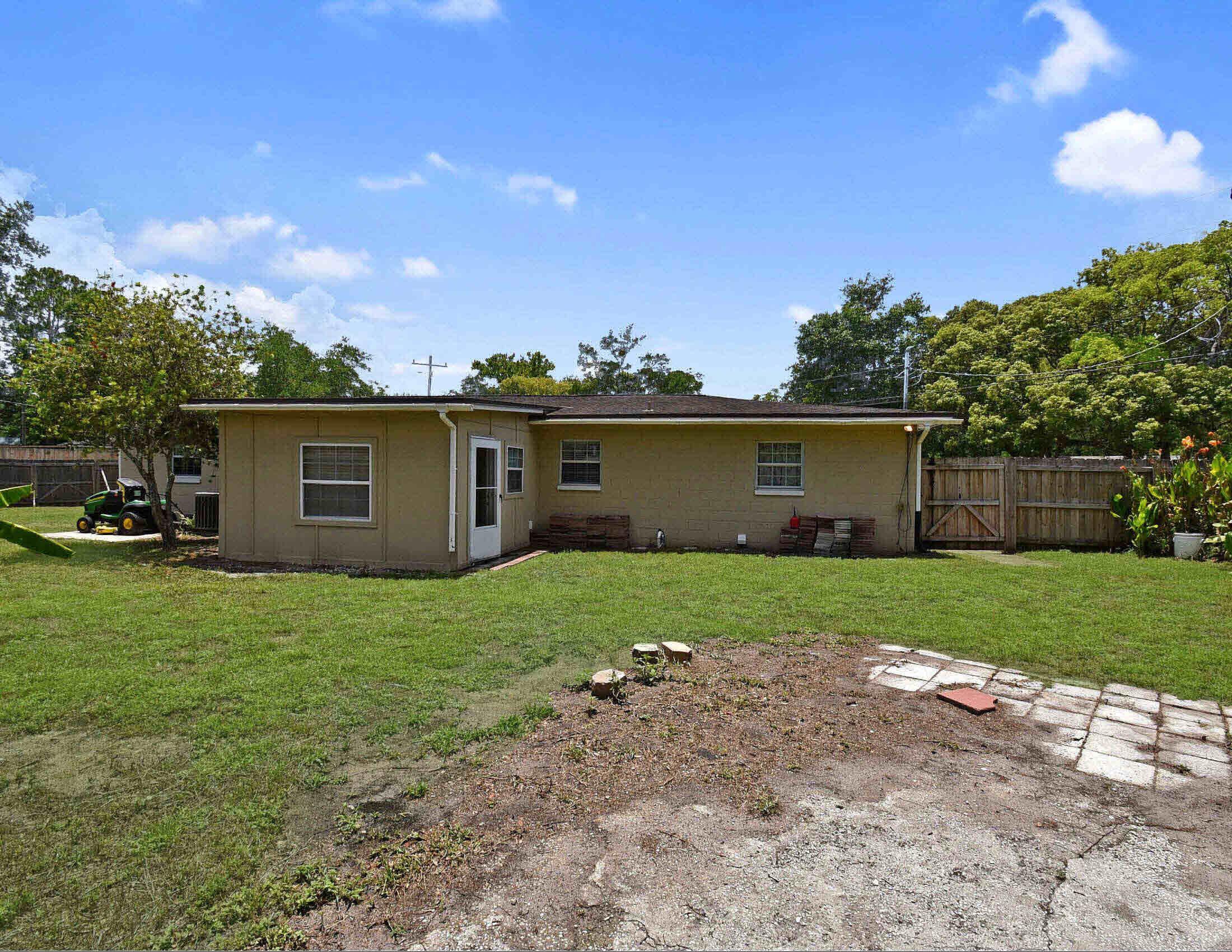 10403 Ebbitt Road Jacksonville, FL 32246 - Photo 3 of 22 a view of a backyard with potted plants and a large tree