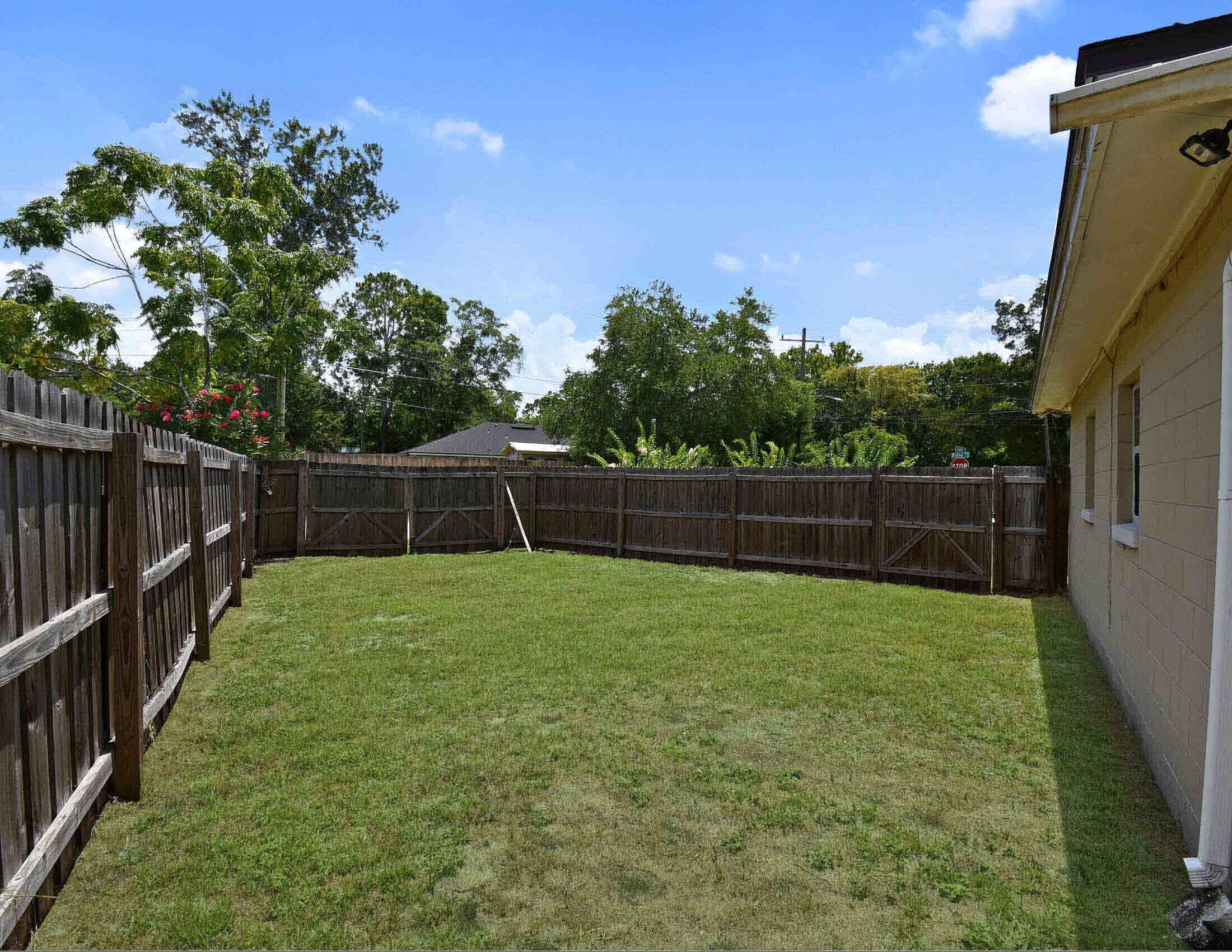 10403 Ebbitt Road Jacksonville, FL 32246 - Photo 5 of 22 a view of a backyard with a tree and wooden fence