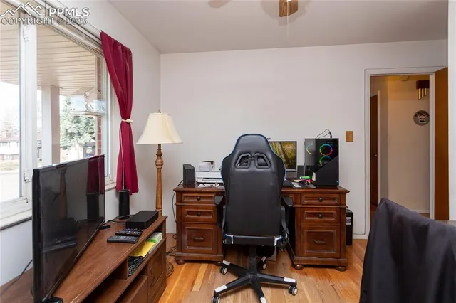 a view of a workspace with furniture and a window