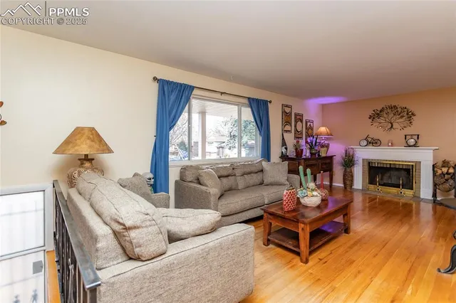 a living room with furniture a fireplace and a large window