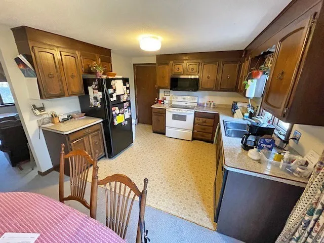a view of a kitchen with fridge and workspace