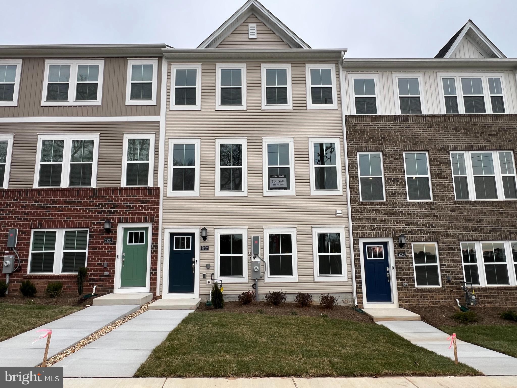 a front view of a residential apartment building with a yard