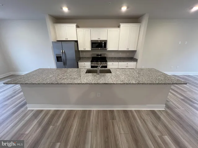 a view of kitchen sink microwave and cabinets