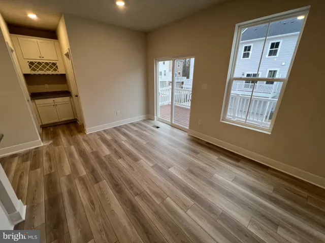 a view of an empty room and a kitchen