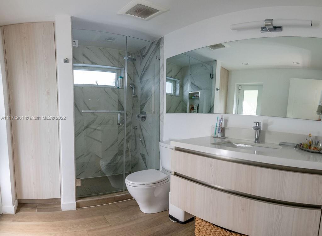 452 Woodcrest Road Key Biscayne, FL 33149 - Photo 19 of 23 a bathroom with a granite countertop sink mirror and toilet