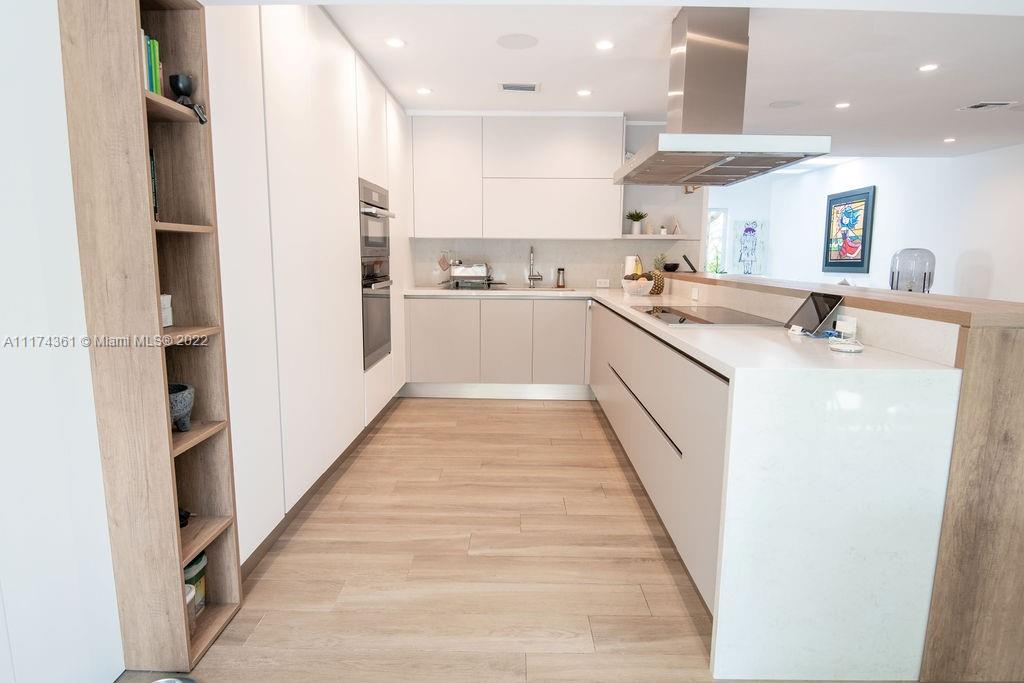 452 Woodcrest Road Key Biscayne, FL 33149 - Photo 6 of 23 a large kitchen with stainless steel appliances kitchen island a large counter top and a stove top oven