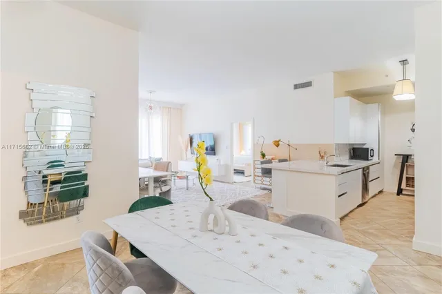 a view of kitchen with kitchen island stainless steel appliances a sink a counter top space and living room view