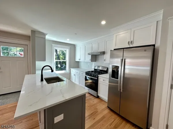 a kitchen with refrigerator and a stove top oven