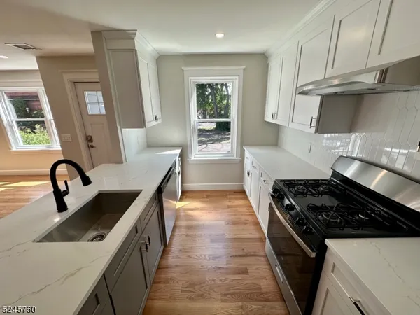 a kitchen with granite countertop a stove and a sink