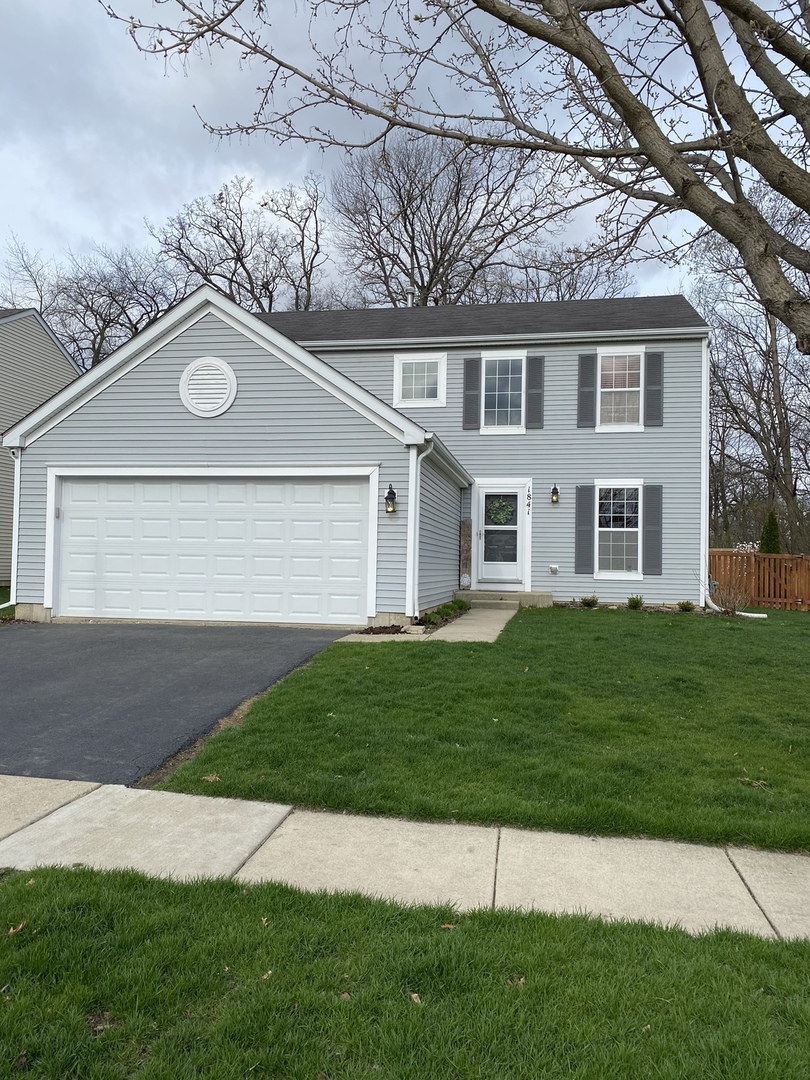 1841 Butterfield Road Woodstock, IL 60098 - Photo 1 of 26 a front view of a house with a garden
