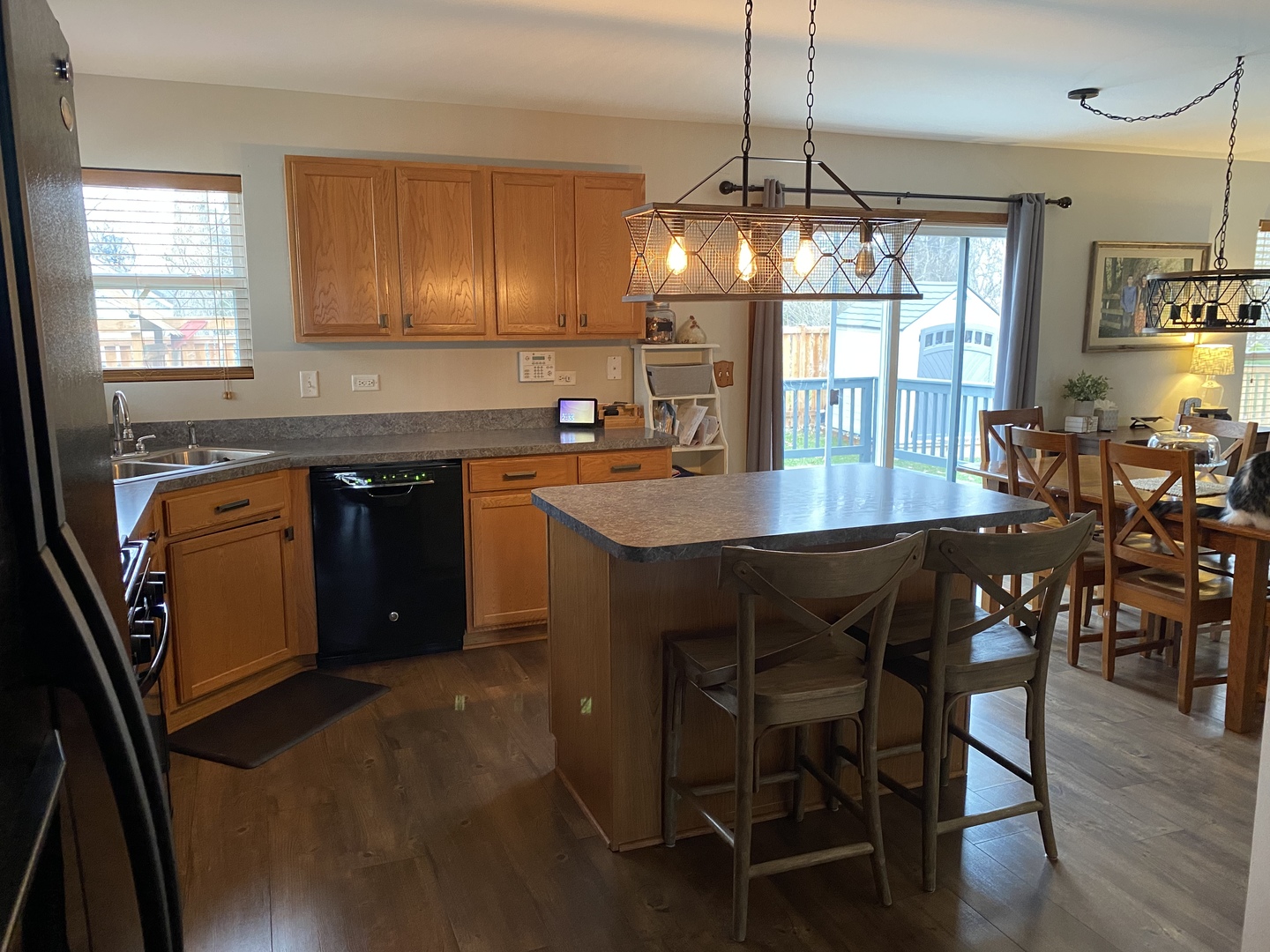 1841 Butterfield Road Woodstock, IL 60098 - Photo 11 of 26 a kitchen with stainless steel appliances granite countertop a sink a stove a dining table and chairs