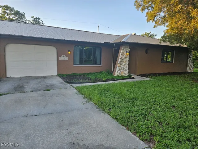 a view of a house with a yard and a garage