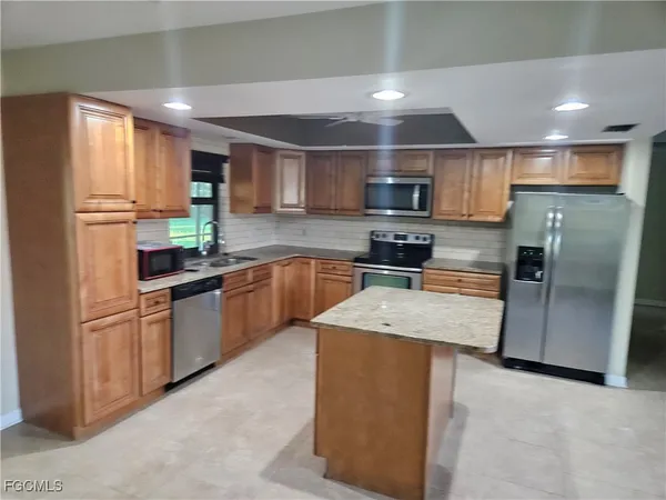 a kitchen with stainless steel appliances granite countertop a refrigerator sink and microwave