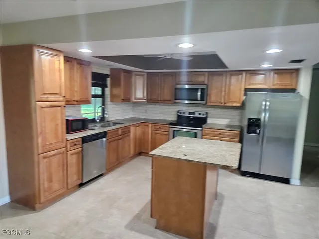 a kitchen with stainless steel appliances granite countertop a refrigerator sink and microwave