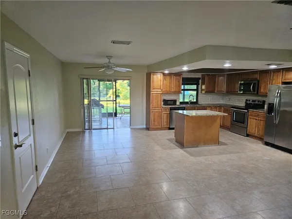 a view of a kitchen with a sink wooden cabinets and a fireplace