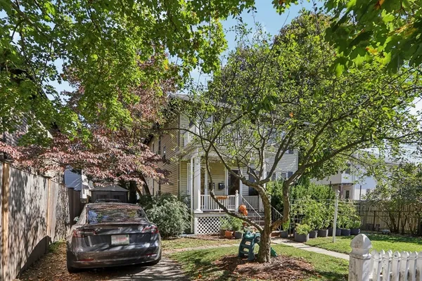 a view of a parked car in front of a brick house