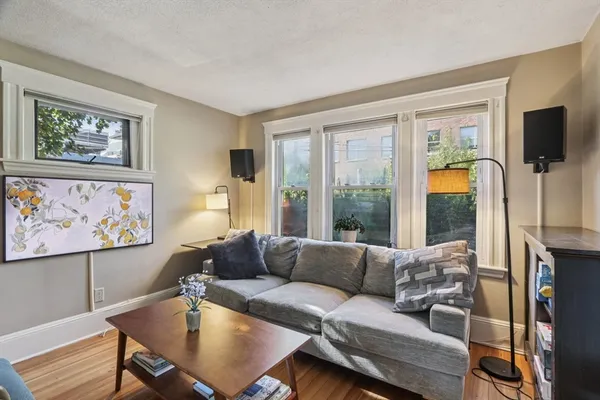 a living room with furniture a flat screen tv and a large window