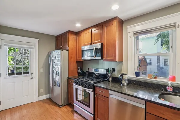 a kitchen with stainless steel appliances granite countertop a refrigerator and a sink