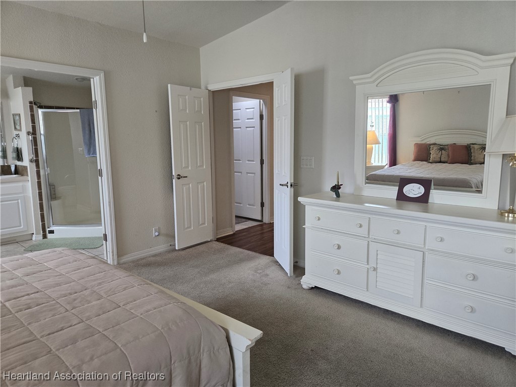 3312 Beartooth Pass Sebring, FL 33872 - Photo 23 of 39 a spacious bedroom with a double vanity sink and a mirror