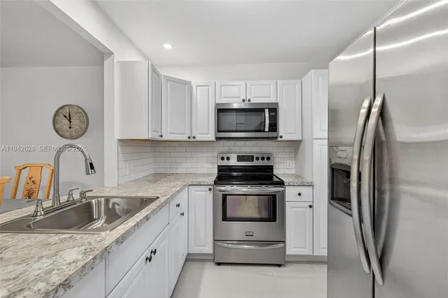 a kitchen with stainless steel appliances a stove a sink and a refrigerator