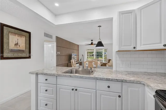 a kitchen with granite countertop a sink and cabinets