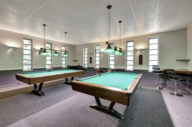 a room with pool tables and windows