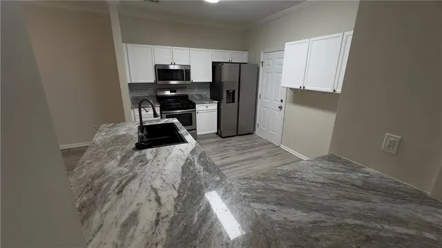 a kitchen with a refrigerator and a stove top oven