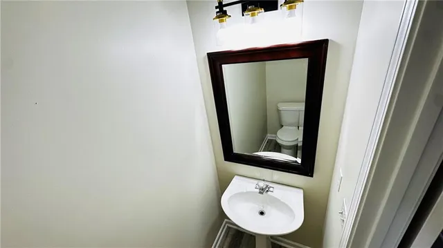 a bathroom with a toilet sink and mirror
