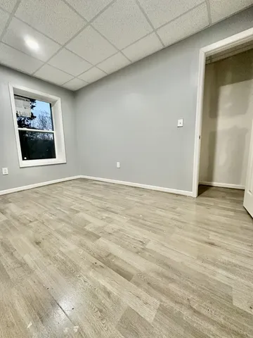 a view of a brick house with large windows and a small yard