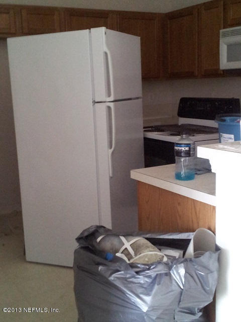 7920 Merrill Road, Unit 1701 Jacksonville, FL 32277 - Photo 7 of 8 a kitchen with a refrigerator and cabinets