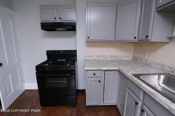 a kitchen with granite countertop a stove and a sink