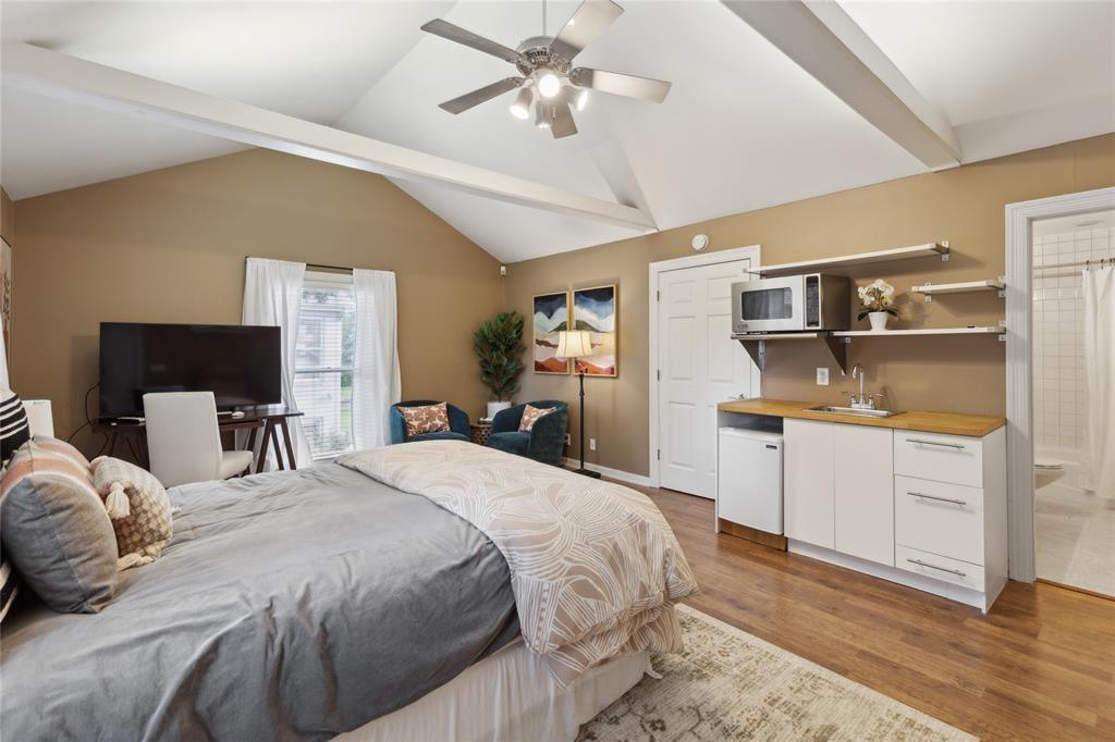 7515 Marquette Street Dallas, TX 75225 - Photo 21 of 25 a bed room with a bed and a chandelier