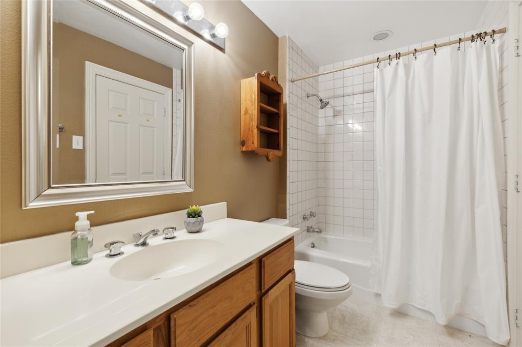 7515 Marquette Street Dallas, TX 75225 - Photo 22 of 25 a bathroom with a sink a toilet and shower curtain