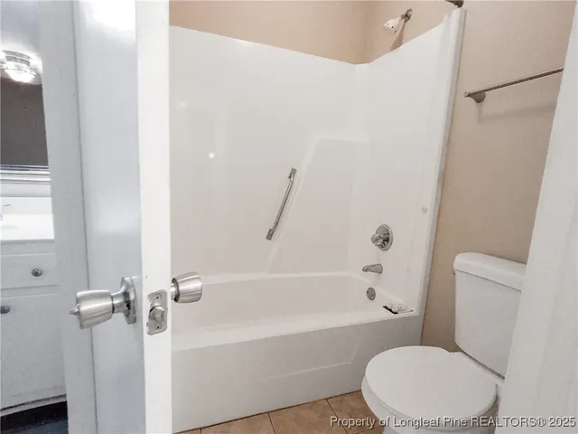 a white toilet sitting next to a bath tub