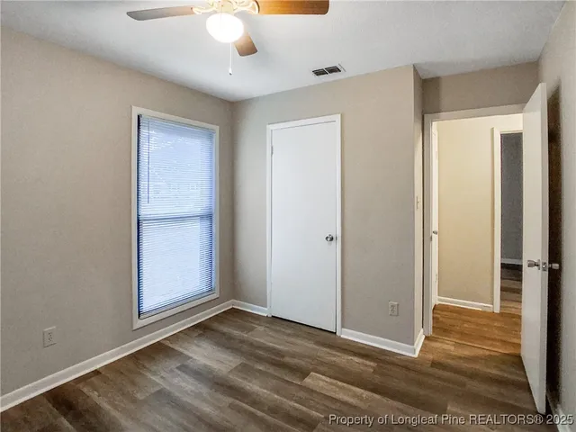 an empty room with closet and a chandelier fan