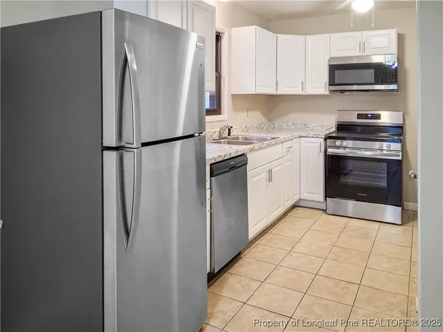 a kitchen with stainless steel appliances a refrigerator sink and microwave