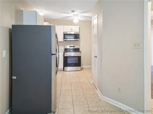 a view of a kitchen with a sink and refrigerator