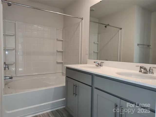 a bathroom with a tub sink shower and mirror