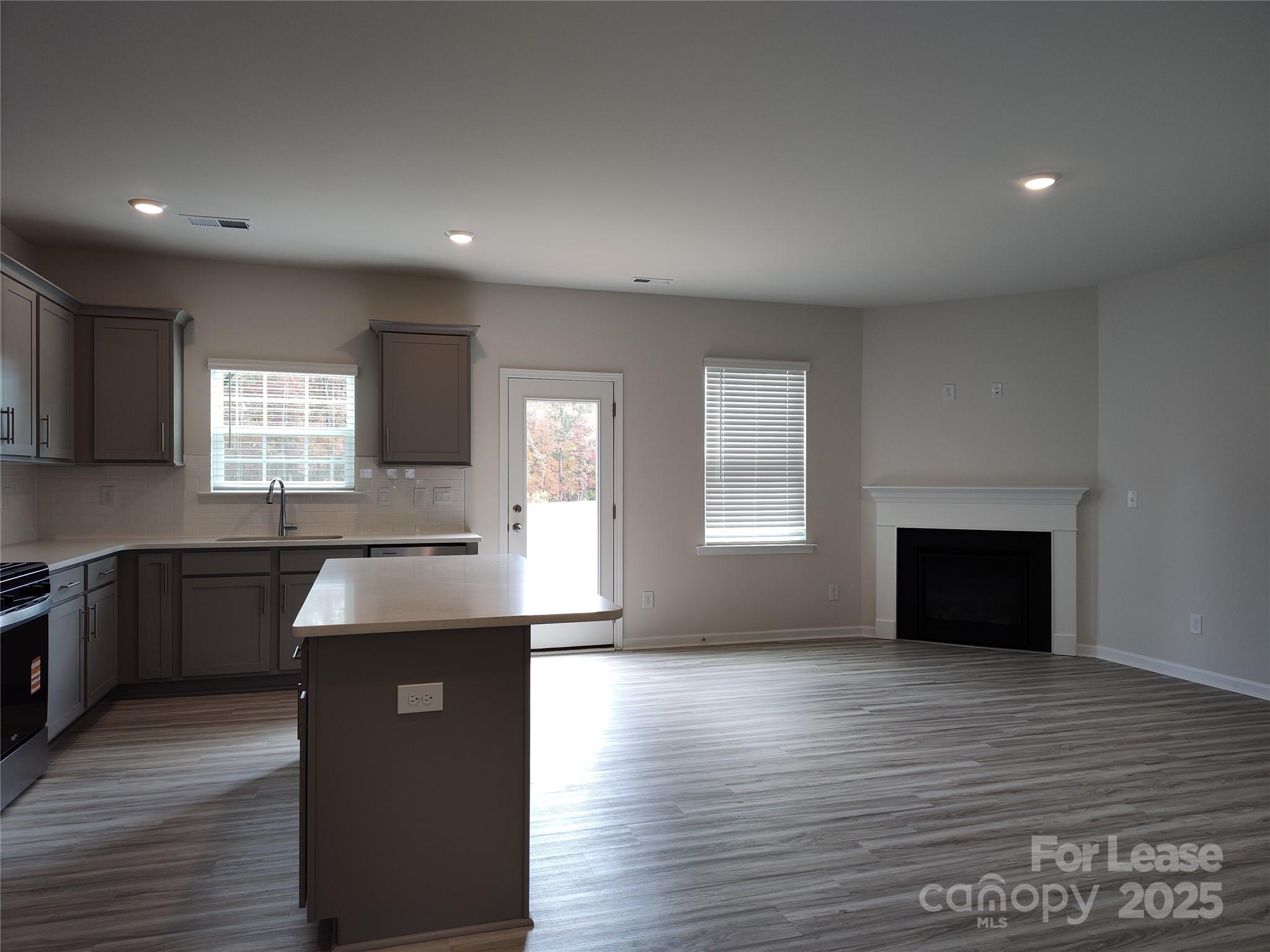 1404 Secrest Cmns Drive Monroe, NC 28112 - Photo 7 of 31 a kitchen with granite countertop a stove a sink and a wooden floor
