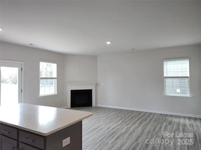 an empty room with windows and fireplace